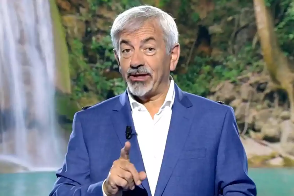 Carlos Sobera vestit amb americana blava i camisa blanca parlant davant d’un fons de cascada i vegetació. Captura de 'Supervivientes'