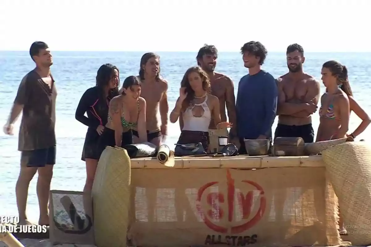 Els concursants de 'Supervivientes' i Laura Madrueño amb una taula de fusta i objectes diversos. Captura de 'Supervivientes' el 23 de juny de 2024
