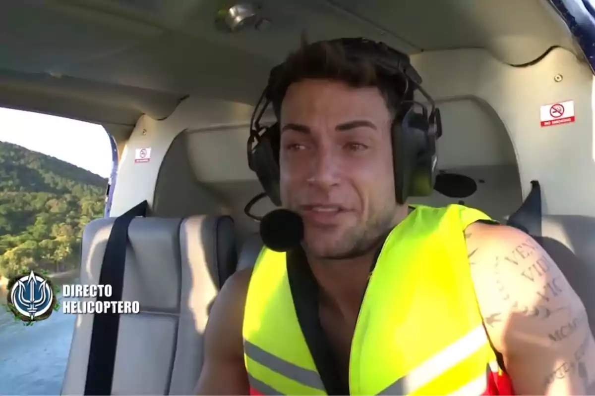 Montoya con chaleco reflectante y auriculares con micrófono está sentado dentro de un helicóptero, con un paisaje verde visible por la ventana. Captura de 'Supervivientes' Montoya con chaleco reflectante y auriculares con micrófono está sentado dentro de un helicóptero, con un paisaje verde visible por la ventana. Captura de 'Supervivientes'