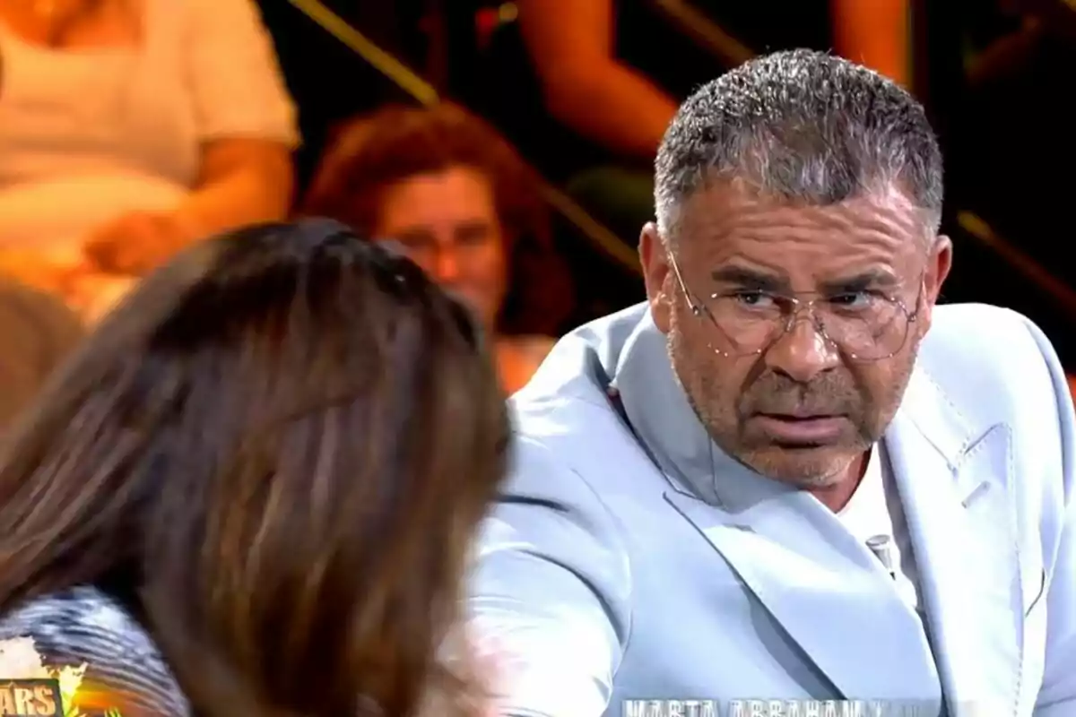 Jorge Javier Vázquez con gafas y traje claro mira con seriedad a Olga Moreno de cabello largo en 'Supervivientes'. Captura el 8 de julio de 2024 Jorge Javier Vázquez con gafas y traje claro mira con seriedad a Olga Moreno de cabello largo en 'Supervivientes'. Captura el 8 de julio de 2024