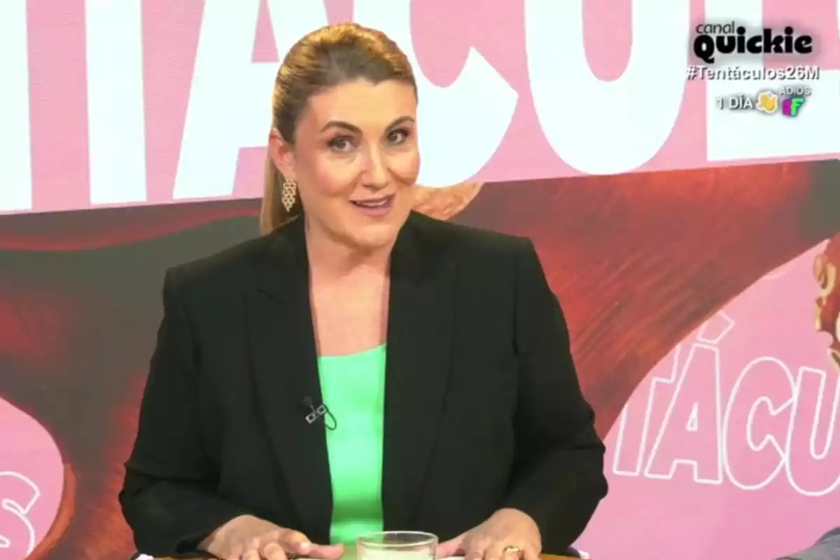 Carlota Corredera con vestimenta formal está sentada frente a un fondo colorido con texto grande. Captura de 'Tentáculos'