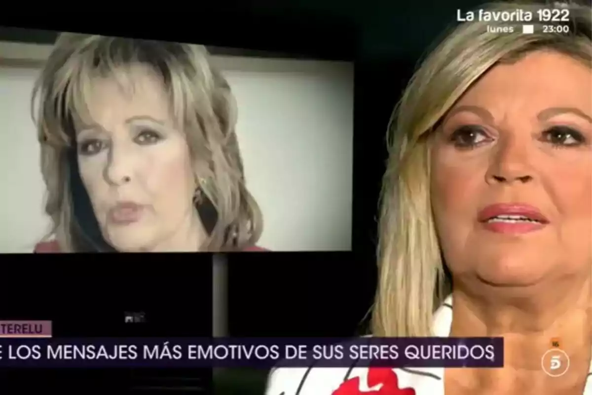 Terelu Campos rubia aparece en primer plano mientras en el fondo se muestra una imagen de María Teresa Campos en una pantalla grande, con un texto en la parte inferior que menciona mensajes emotivos en De Viernes. Terelu Campos rubia aparece en primer plano mientras en el fondo se muestra una imagen de María Teresa Campos en una pantalla grande, con un texto en la parte inferior que menciona mensajes emotivos en De Viernes.