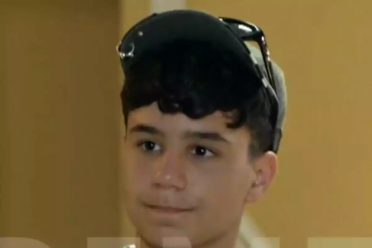 Toñín con gorra y gafas de sol sobre la cabeza en un ambiente interior en La que se avecina. Toñín con gorra y gafas de sol sobre la cabeza en un ambiente interior en La que se avecina.