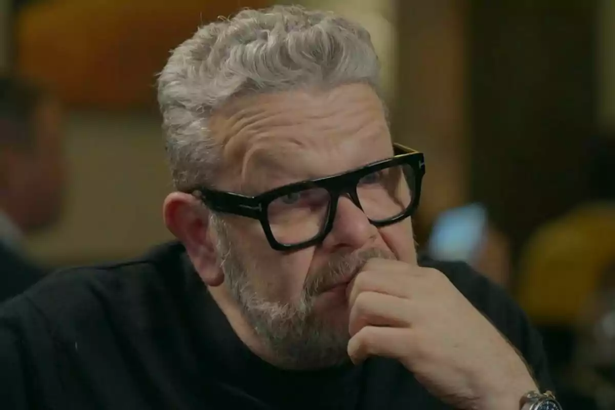 Alberto Chicote con gafas negras y cabello canoso mira pensativo hacia un lado mientras se apoya en su mano en Batalla de Restaurantes.