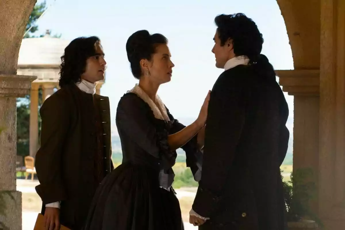 Alejo, Mercedes y José Luis vestidas con ropa de época están en una conversación seria bajo un arco de piedra en un entorno al aire libre. Captura de 'Valle Salvaje' Alejo, Mercedes y José Luis vestidas con ropa de época están en una conversación seria bajo un arco de piedra en un entorno al aire libre. Captura de 'Valle Salvaje'