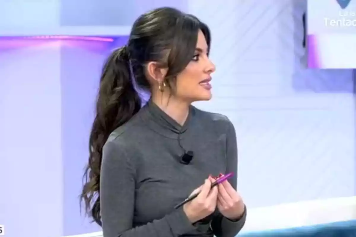 Alexia Rivas con cabello largo y oscuro recogido en una coleta, vestida con un suéter gris, sostiene un bolígrafo rosa mientras parece estar hablando en un entorno de estudio de televisión. Captura de 'Vamos a ver' Alexia Rivas con cabello largo y oscuro recogido en una coleta, vestida con un suéter gris, sostiene un bolígrafo rosa mientras parece estar hablando en un entorno de estudio de televisión. Captura de 'Vamos a ver'