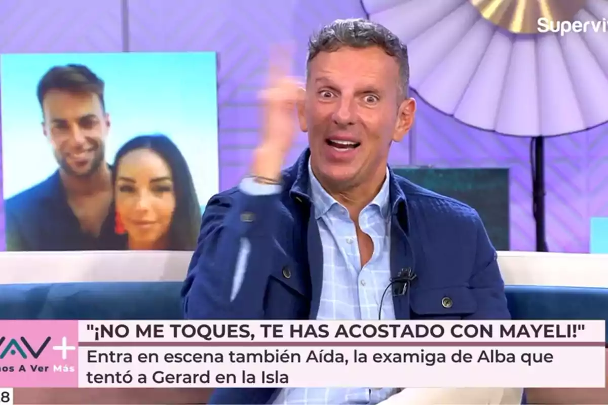 Joaquín Prat gesticula mientras está sentado en un set de televisión con un fondo colorido y un cartel que muestra a una pareja detrás de él. Captura de 'Vamos a ver' Joaquín Prat gesticula mientras está sentado en un set de televisión con un fondo colorido y un cartel que muestra a una pareja detrás de él. Captura de 'Vamos a ver'