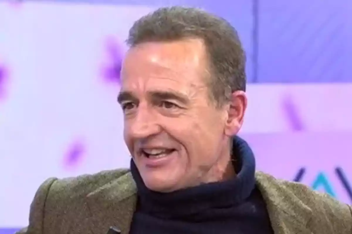Alessandro Lequio sonriente con un suéter oscuro y una chaqueta marrón en un entorno de estudio de televisión. Captura de 'Vamos a Ver' Alessandro Lequio sonriente con un suéter oscuro y una chaqueta marrón en un entorno de estudio de televisión. Captura de 'Vamos a Ver'