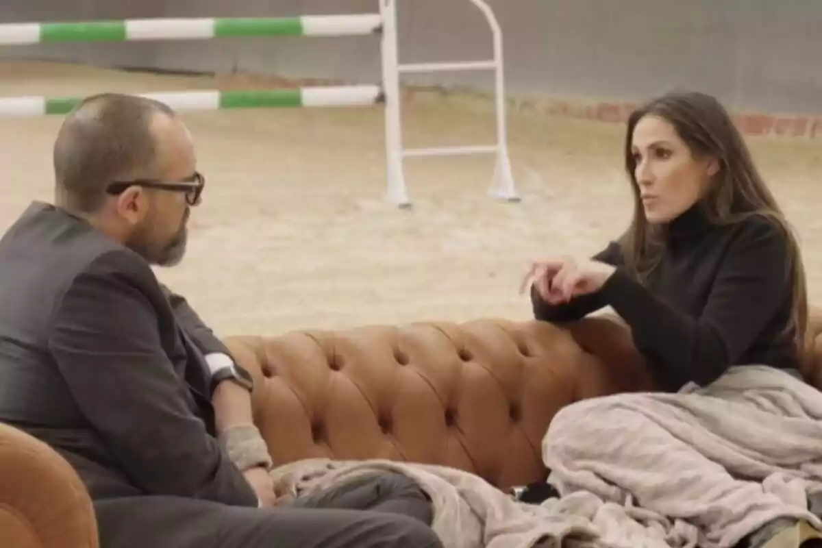 Captura de 'Viajando con Chester' con Risto Mejide y Malú sentados en un sofá marrón mientras hablan