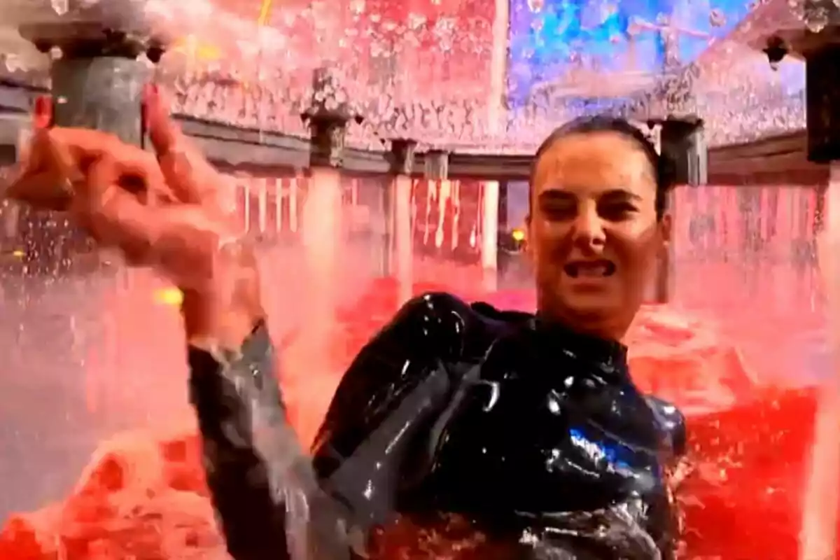 Victoria Federica con expresión de esfuerzo está en un entorno lleno de agua roja y salpicaduras, posiblemente participando en un desafío o juego en El Desafío.