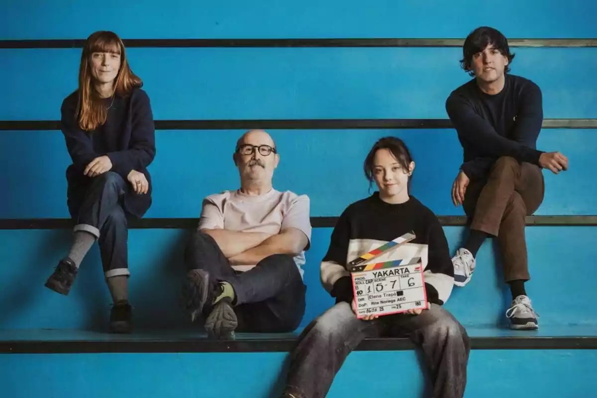 Javier Cámara, Carla Quílez, Diego San José y Elena Trapezoidal en una estructura de escalones frente a una pared azul, una de ellas sostiene una claqueta de cine en el final de rodaje de 'Yakarta'. Javier Cámara, Carla Quílez, Diego San José y Elena Trapezoidal en una estructura de escalones frente a una pared azul, una de ellas sostiene una claqueta de cine en el final de rodaje de 'Yakarta'.