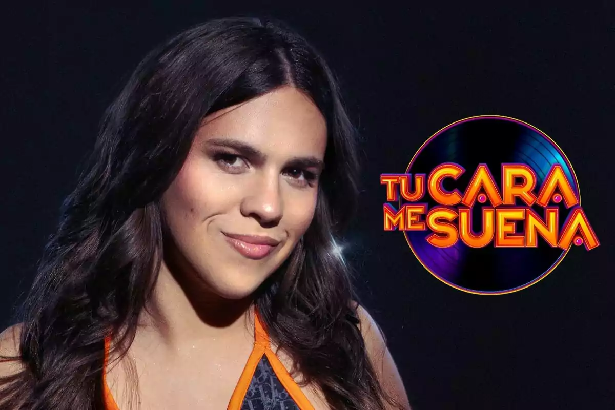 Yenesi con cabello largo y oscuro sonríe frente a un fondo oscuro, junto al logo del programa "Tu Cara Me Suena".