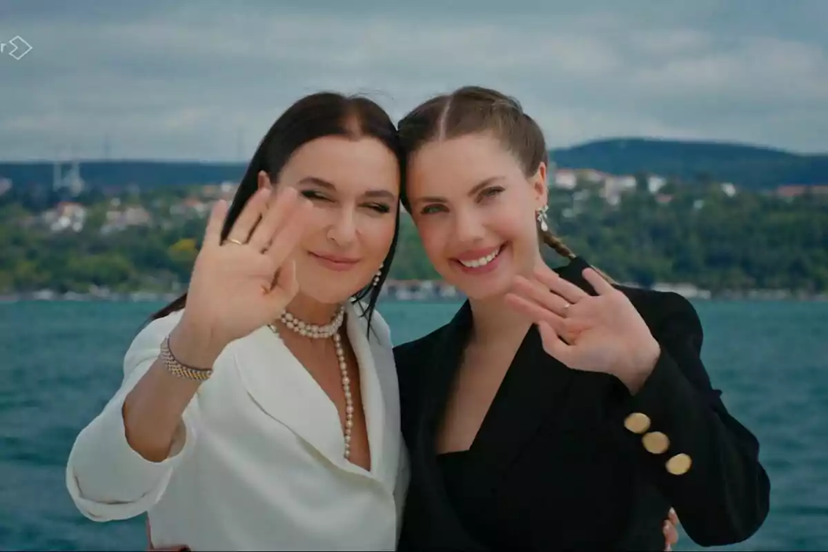 Yildiz y Ender sonrientes saludando con la mano frente a un paisaje costero en el final de Pecado Original Yildiz y Ender sonrientes saludando con la mano frente a un paisaje costero en el final de Pecado Original